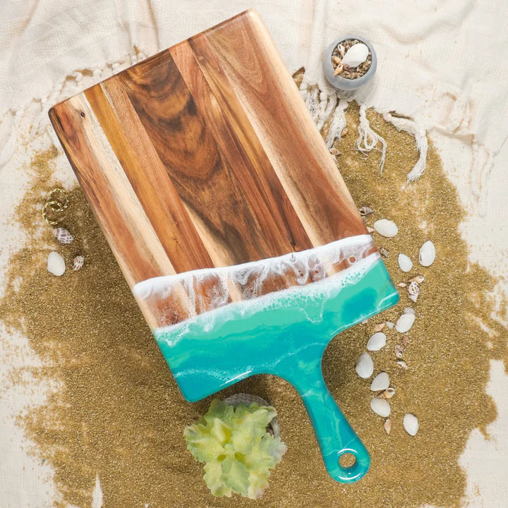 large acacia wood cutting board with handle and aqua resin accents