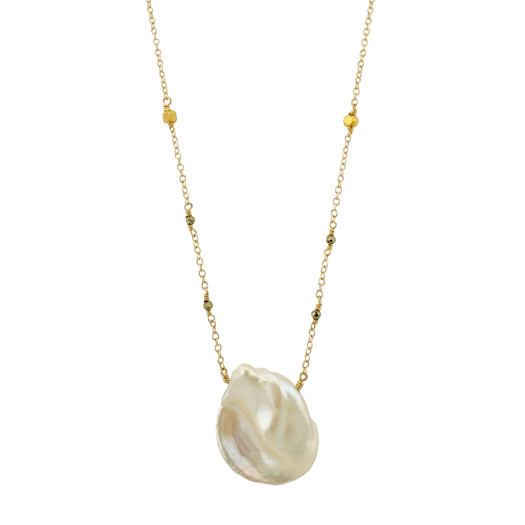 Necklace with a large shell pendant on a gold chain against a white background
