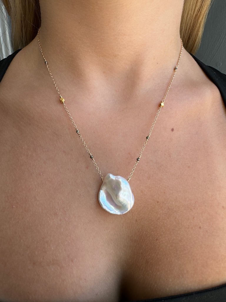 large pearl necklace on persons neck