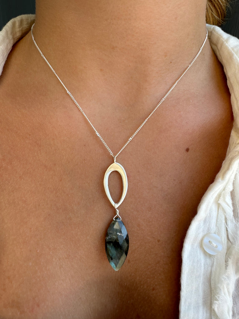 Necklace with a leaf pendant and labradorite on a person's neck