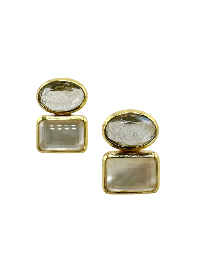 Pair of earrings with gold frames and clear stone centers on a white background
