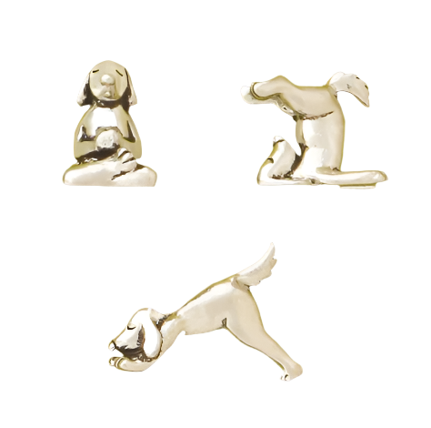 A set of three pewter miniature figurines depicting dogs in different yoga poses.