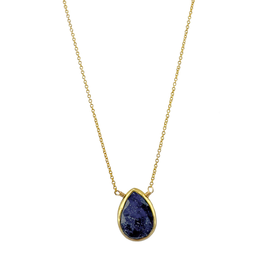 Necklace with a teardrop-shaped blue pendant on a gold chain against a white background
