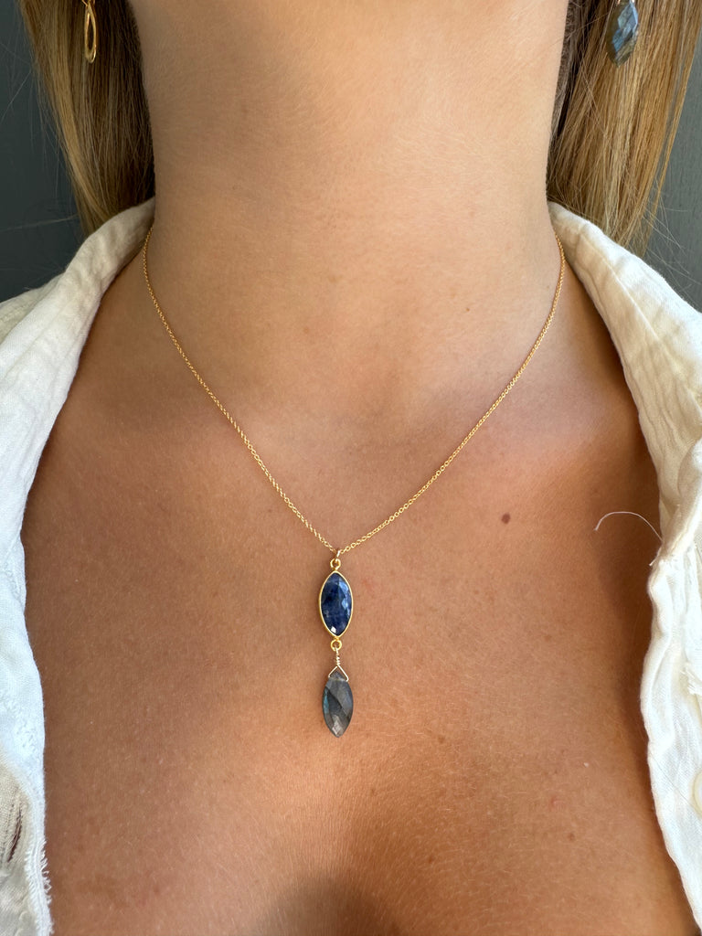 Gold chain with blue stones on a person's neck