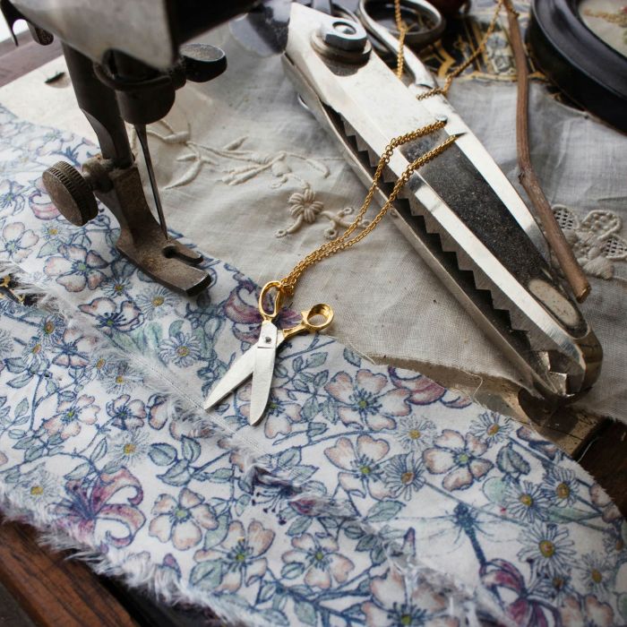 shearing scissors necklace resting on floral fabric