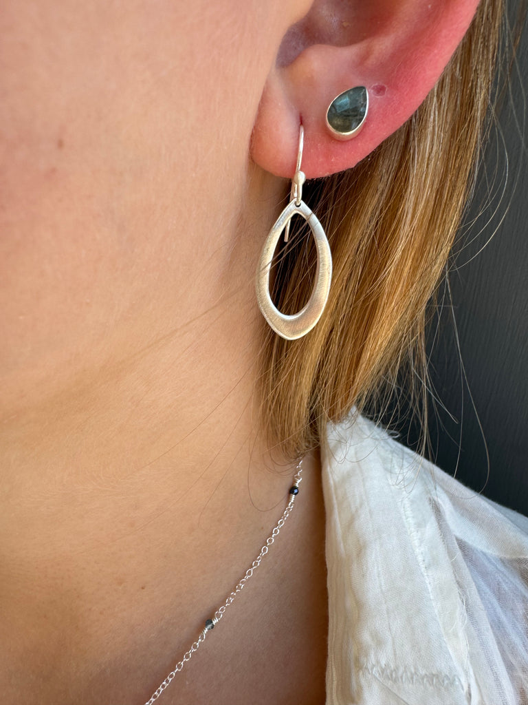 small leaf earrings on persons ear