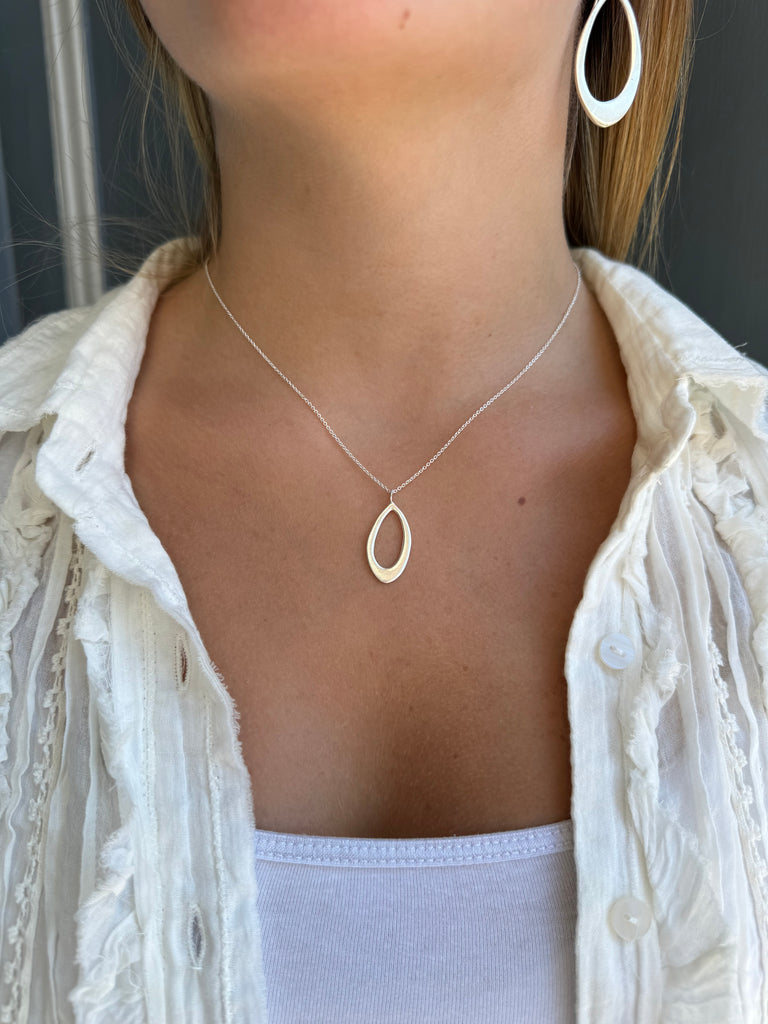 small leaf necklace on persons neck
