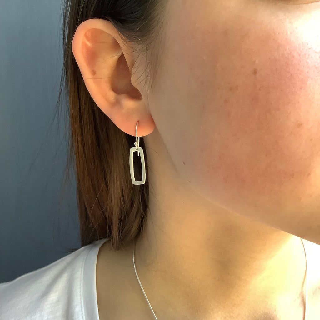 small rectangle earrings in silver on the ear