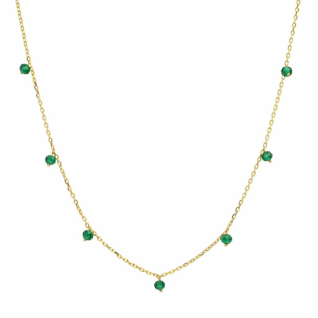 Gold necklace with emerald green gemstones on a white background