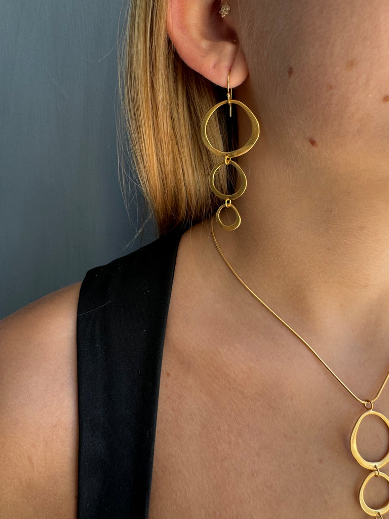 Gold body chain worn by a person with a neutral background