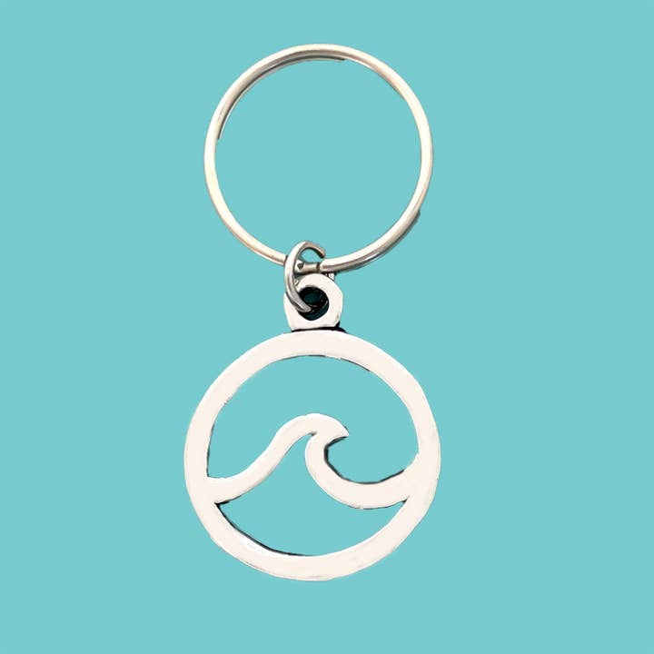 Silver wave-shaped keychain on a turquoise background