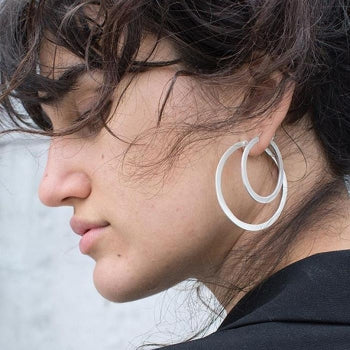 Flat Medium Hoop Earring in silver on women wearing larger hoop as well